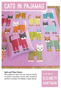 Pink quilt features cats wearing pyjamas of different colours.
