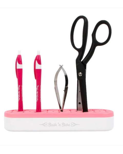 Pink and white stationery set with scissors, pens, and a nail clipper on a white background