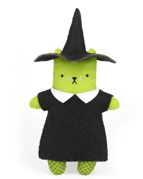 A plush felt witch cat toy with a bright green body, black pointed hat and dress, and a white collar, standing against a plain white background.