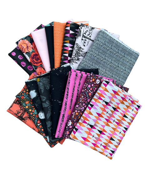 A fan arrangement of multiple folded Halloween fabric pieces with different patterns and colours, including floral, herringbone, geometric, and black-and-white designs, on a plain white background.