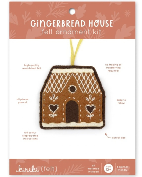 Kiriki (felt) gingerbread house ornament kit in its retail packaging, featuring a brown felt house with cream and white stitched details and a yellow hanging ribbon.