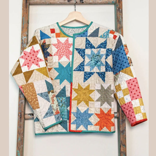 Colorful quilt with star patterns hanging on a wooden ladder.