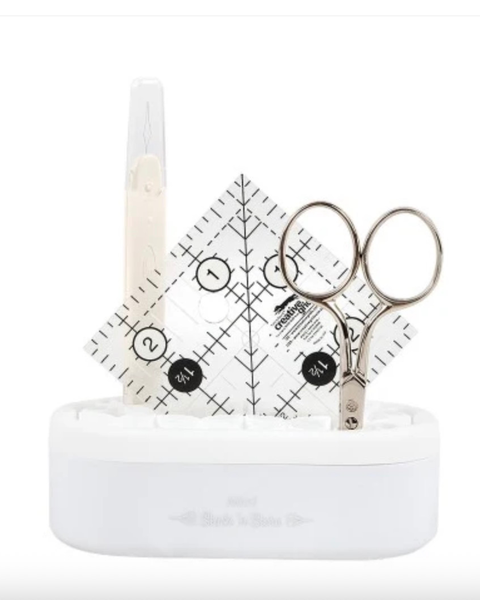 Set of sewing tools including scissors, measuring tape, and ruler on a white background