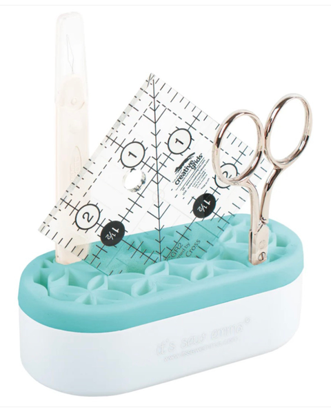 Teal and white sewing kit with ruler and scissors on a white background