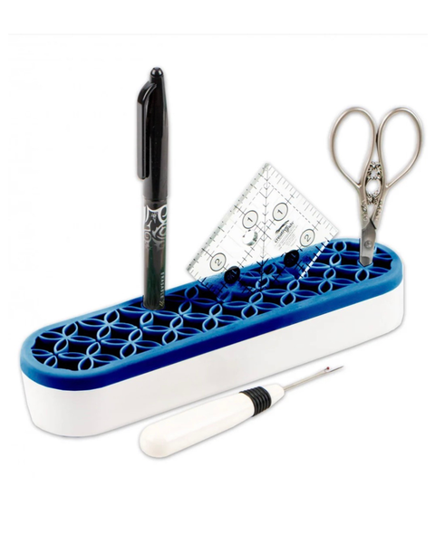Blue and white holder with stationery items including a pen, scissors, and ruler on a white background