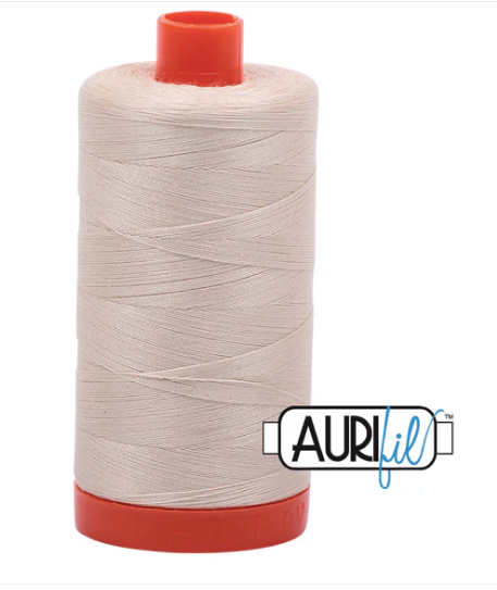 Spool of beige thread with red ends and Aurifil logo on a white background
