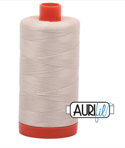 Spool of beige thread with red ends and Aurifil logo on a white background