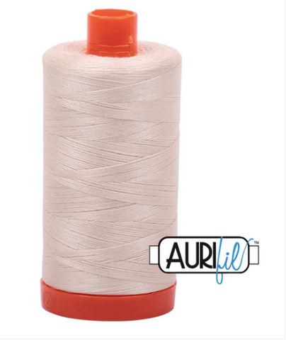 Spool of Aurifil thread with red cap on a white background