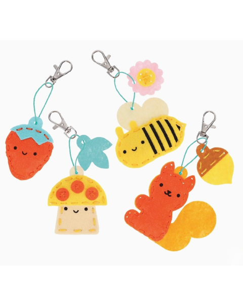 Four colorful felt keychains shaped like a strawberry, a mushroom, a bee, and a squirrel, each with a silver metal clasp on a white background.