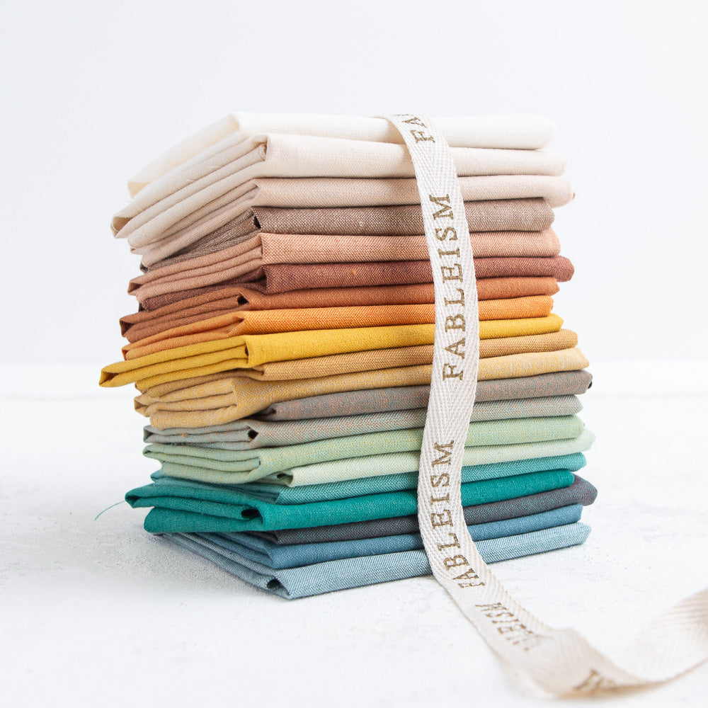 stack of woven fabrics in landscape colours with a ribbon