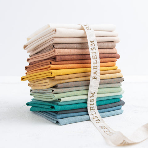 stack of woven fabrics in landscape colours with a ribbon