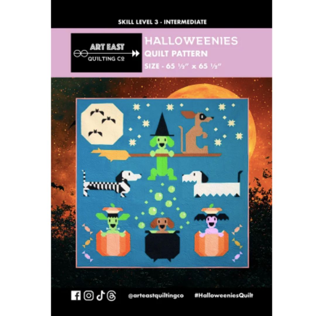 Halloween-themed quilt pattern with cartoon characters on a blue background, featuring Art East Quilting Co branding.