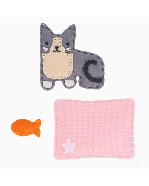 A felt craft kit featuring a gray and beige cat patch, a small orange fish patch, and a pink dotted square patch with a white star, displayed on a clean white background.
