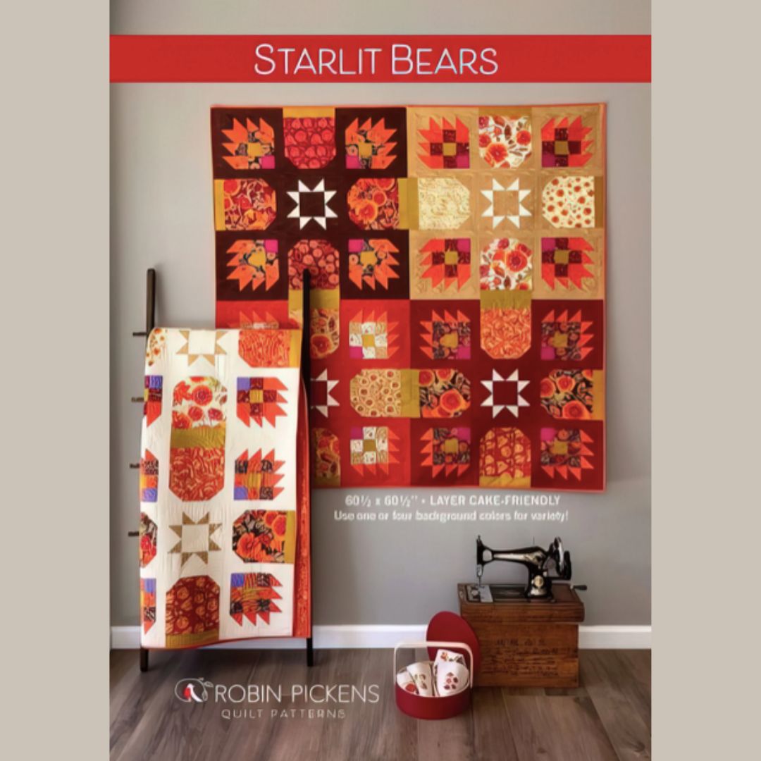 Quilt pattern cover featuring a colorful quilt with starlit bear design, displayed on a stand against a gray wall.